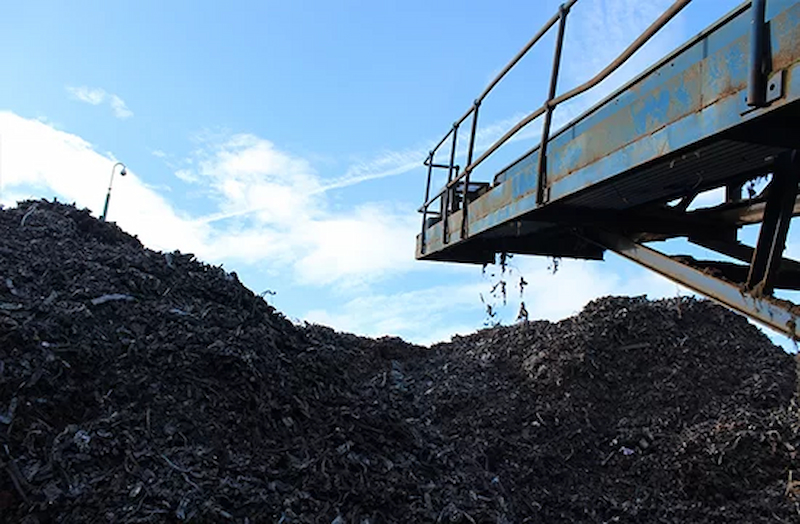 heaps of scrap metal off a conveyer belt