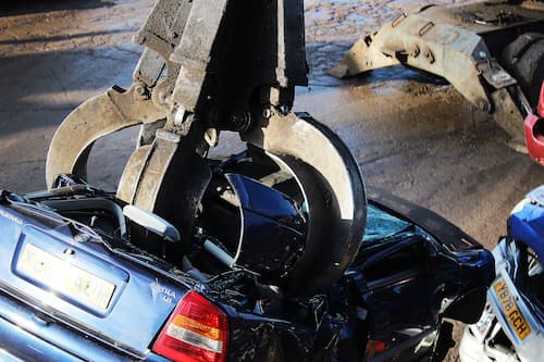 car being scrapped by crane