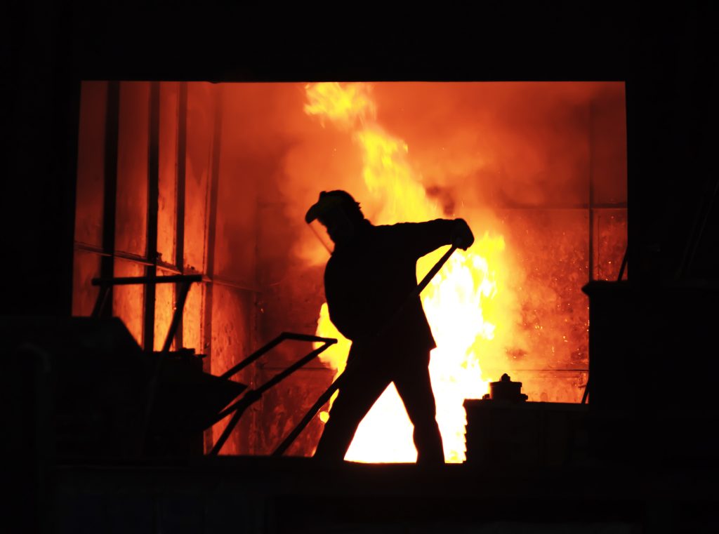 man working with molten iron