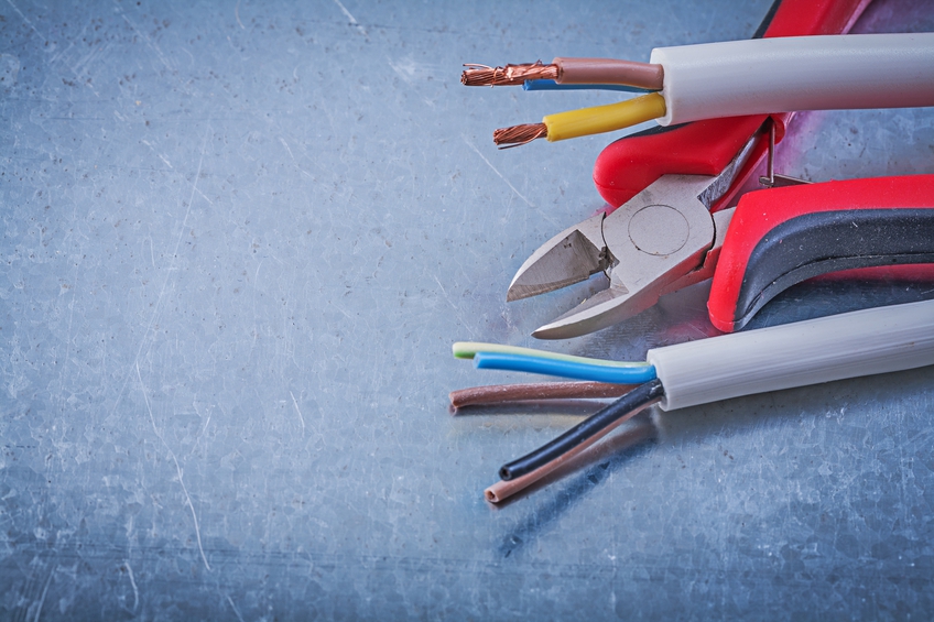 copper Electric cables wires nippers on scratched metallic background