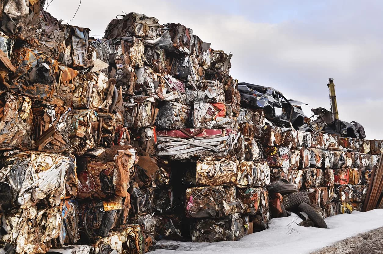 A pile of Compressed Cars Ready to Be Processed For Scrap Metal Recycling