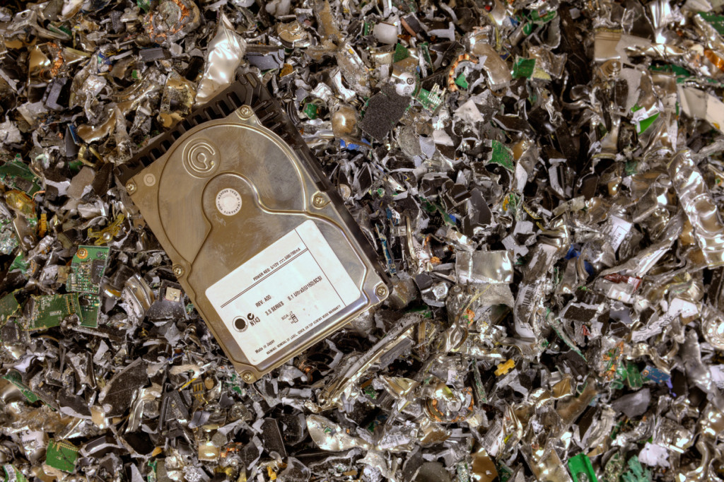 Hard drive resting on a pile of shredded hard drives.