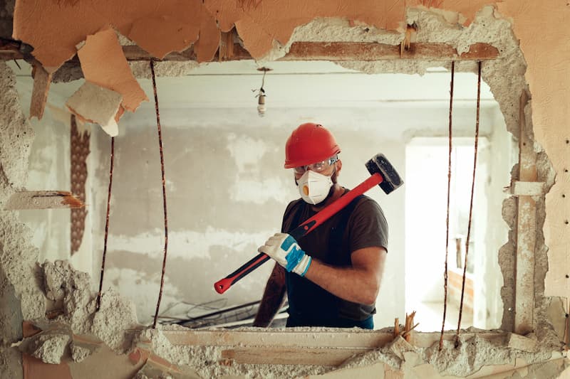 man knocking down a wall