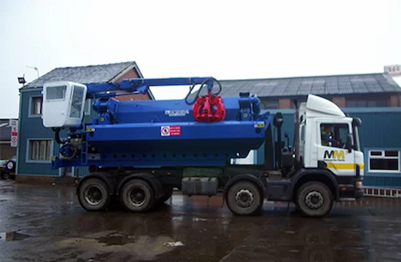 A white and blue Morecambe Metals mobile Baler 